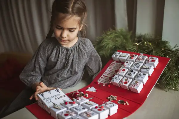 Niña prepara su calendario de adviento, una manualidad navideña para contar los días.